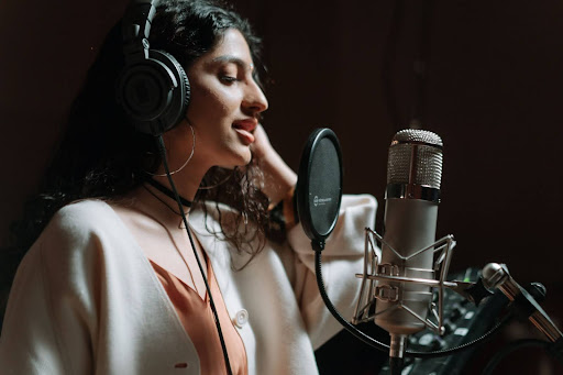 woman in studio singing in front of a microphone | artist development