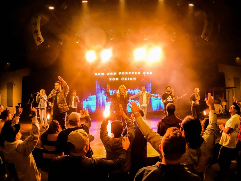 Group of people raising their hands in front of artists